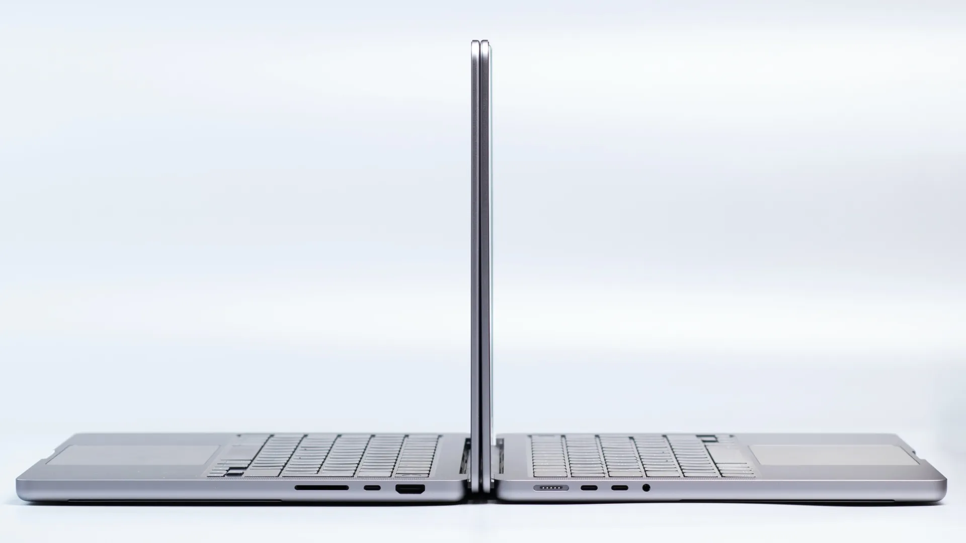 Two MacBook Pro laptops side by side, with their lids open