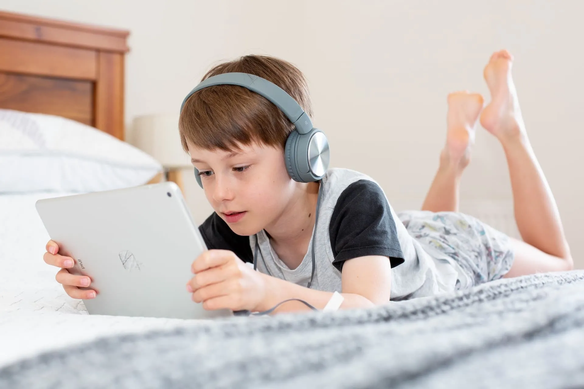 Kind benutzt altes iPad mit Kopfhörern
