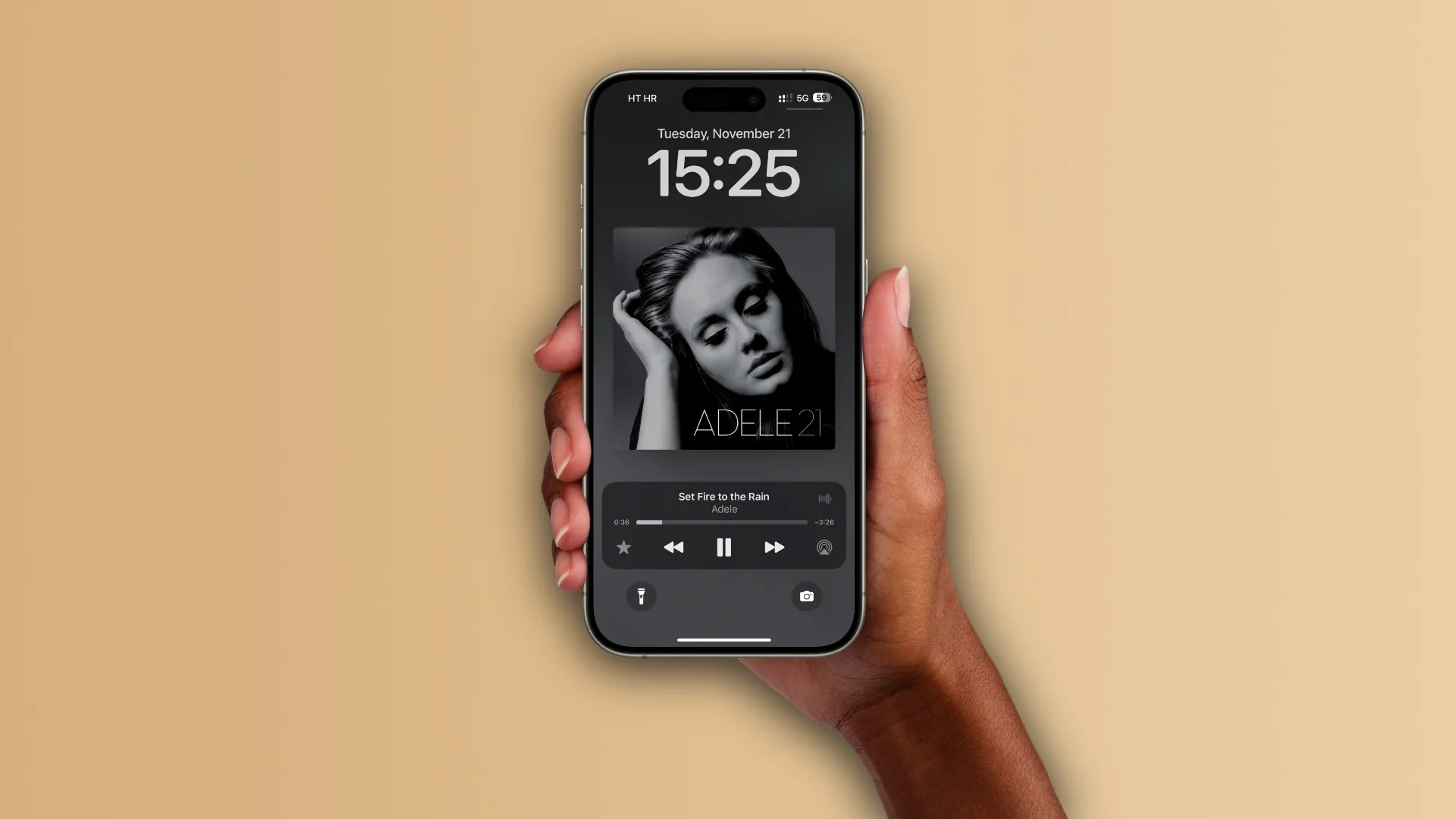 Frauenhände halten ein iPhone, auf dem Sperrbildschirm läuft „Set Fire to the Rain“ von Adele