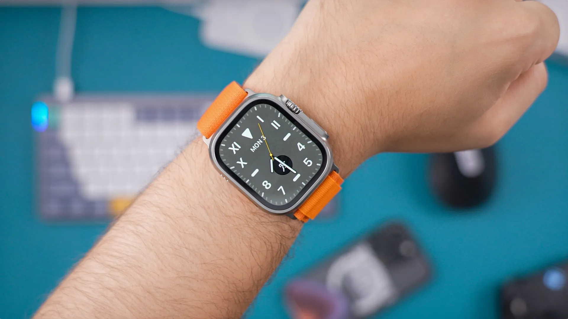 Apple Watch Ultra con correa naranja en muñeca masculina