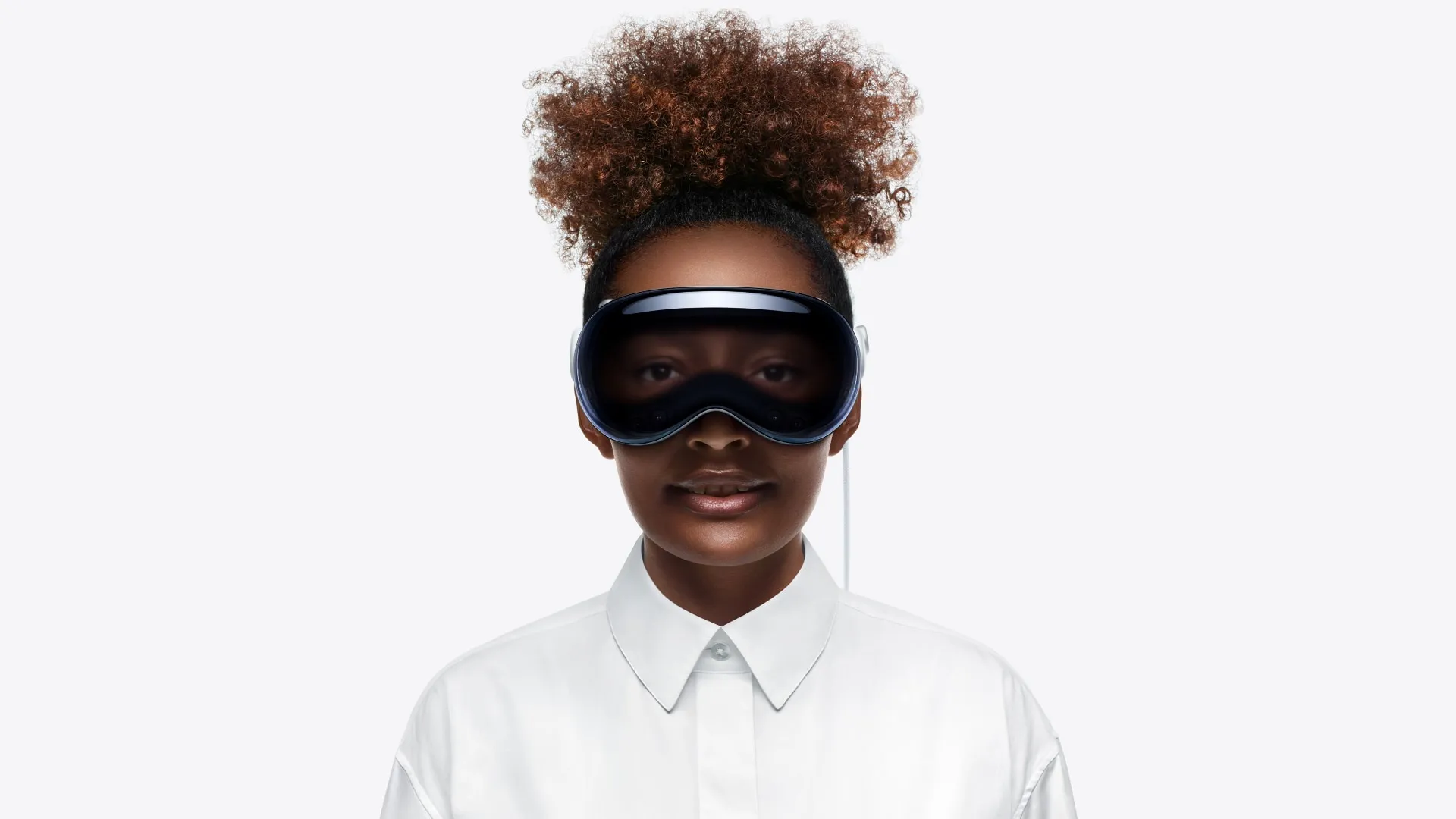 Femme portant un casque Apple Vision Pro, avec EyeSight affichant ses yeux numériques