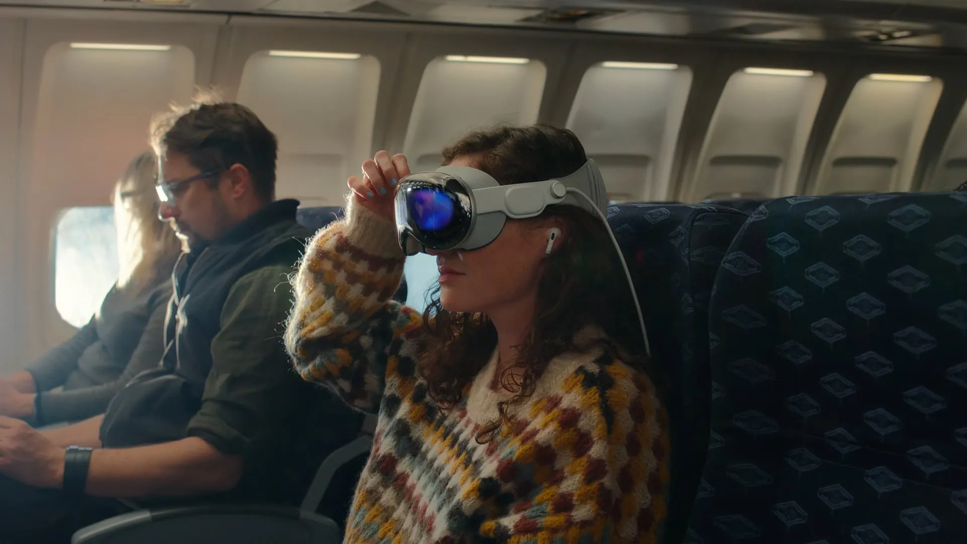 Žena sleduje filmy v letadle na náhlavní soupravě Apple Vision Pro