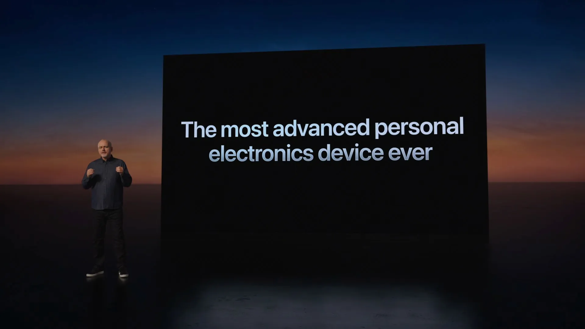 Mike Rockwell d'Apple debout à côté d'une diapositive Vision Pro qui indique