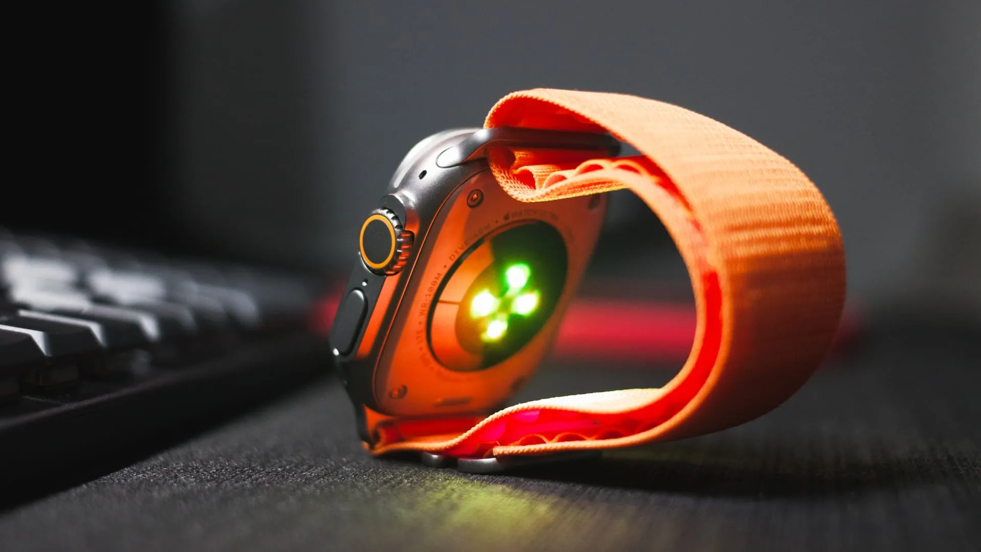 Apple Watch Ultra 2 on desk with blood oxygen sensor LEDs active