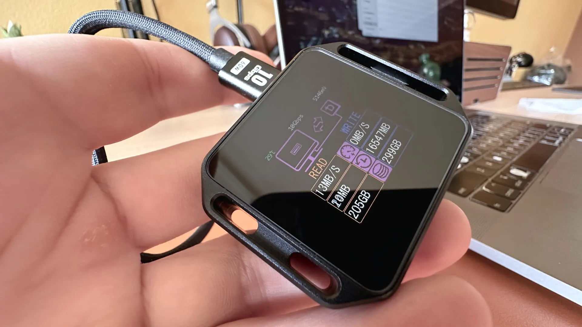 Das SSD-Gehäuse des Dockcase in männlicher Hand, mit aktivem Display