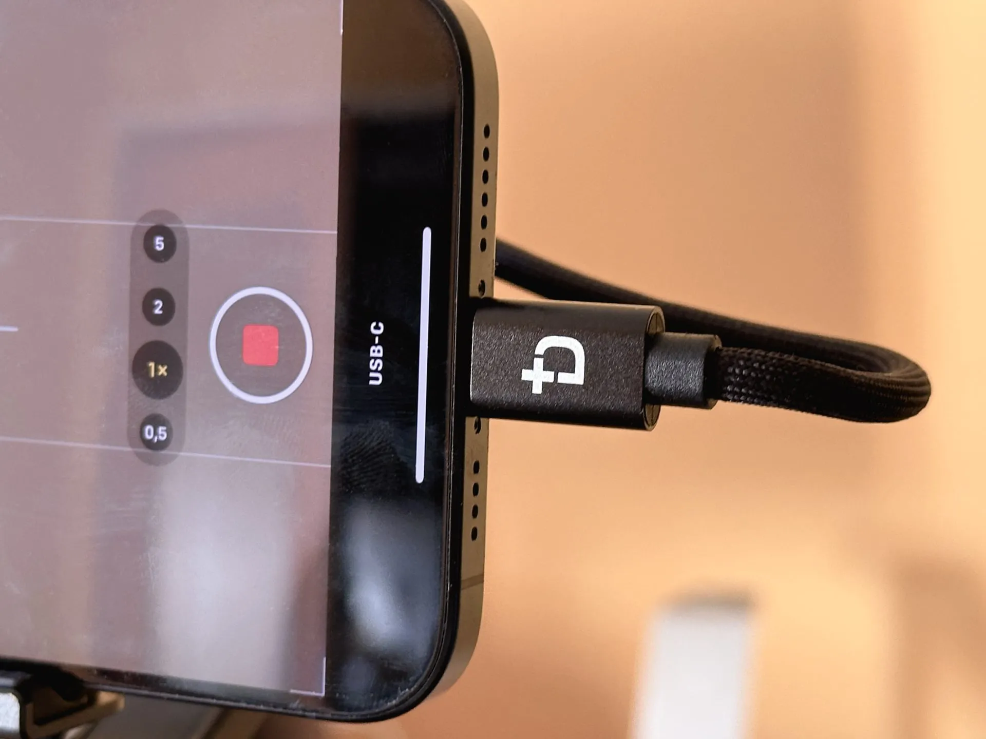 iPhone 15 Pro con un cable Dockcase conectado a su puerto USB-C